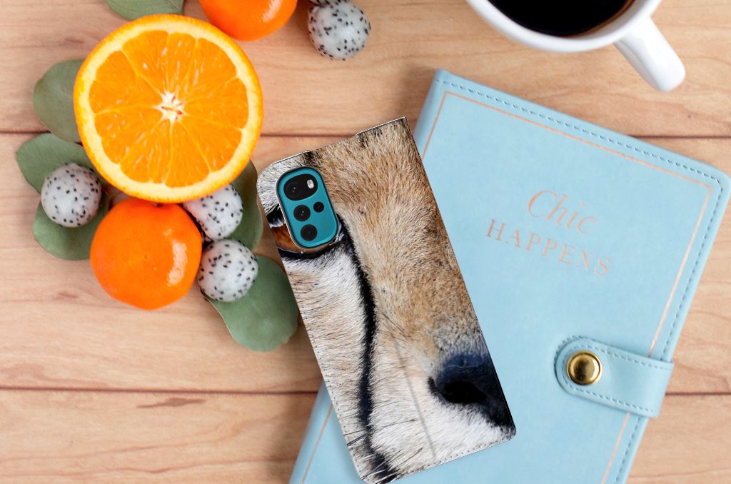 Motorola Moto G22 Hoesje maken Cheetah met close-up van jachtluipaard op een bureau met sinaasappels.