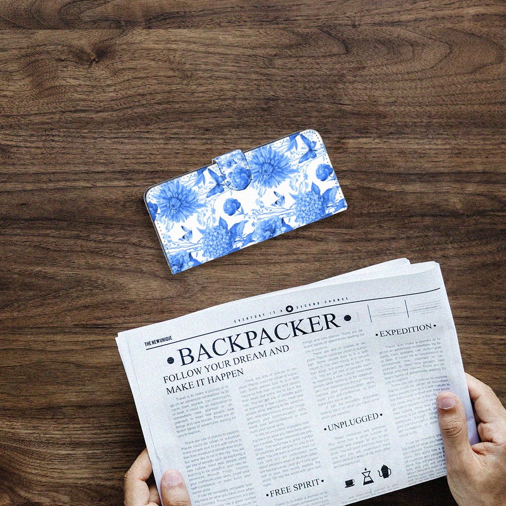 Hoesje voor Samsung Galaxy A14 4G Flowers Blue op een houten tafel met een krant eronder.