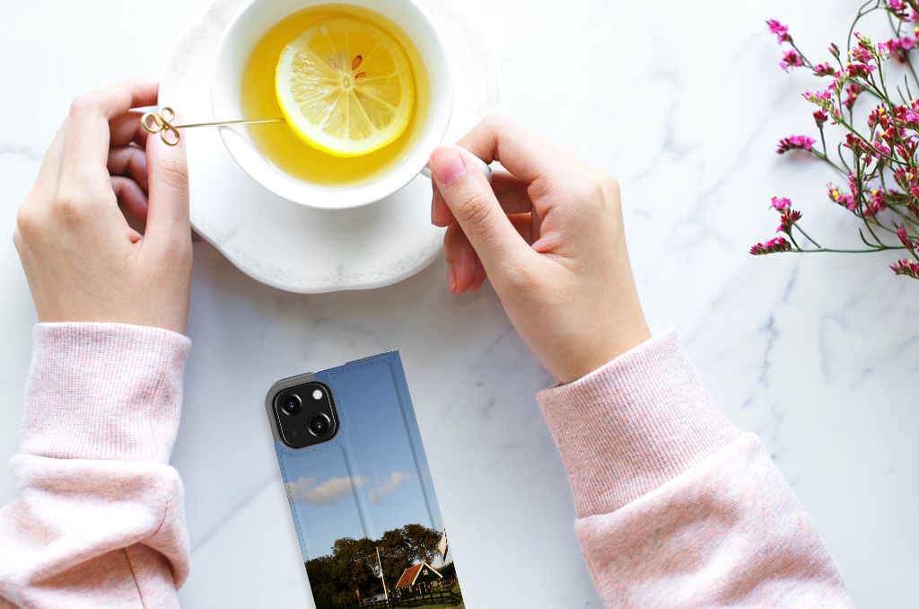 iPhone 13 Mini Book Cover Molen with a scenic view, next to a cup of lemon tea and flowers đŧ.