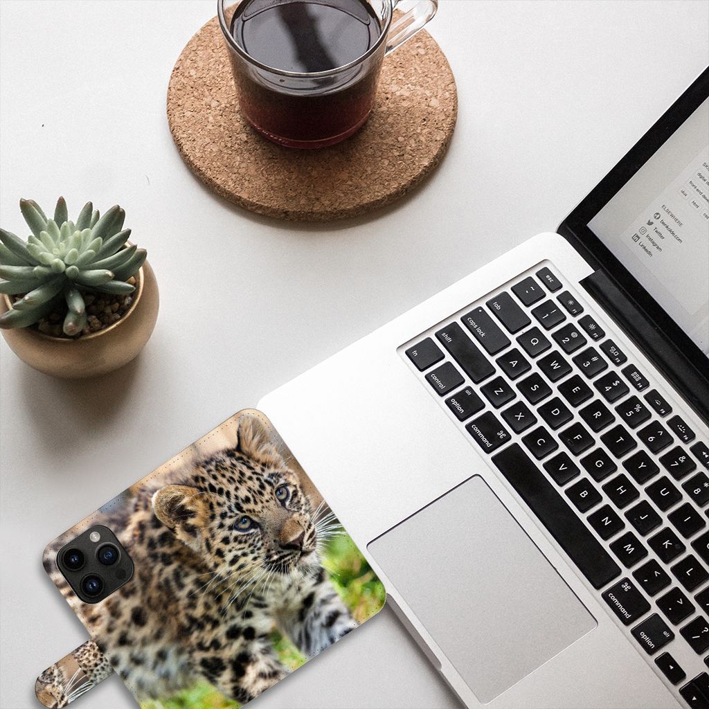 iPhone 15 Pro Telefoonhoesje met Pasjes Baby Luipaard op een bureau met een kopje koffie en een laptop.