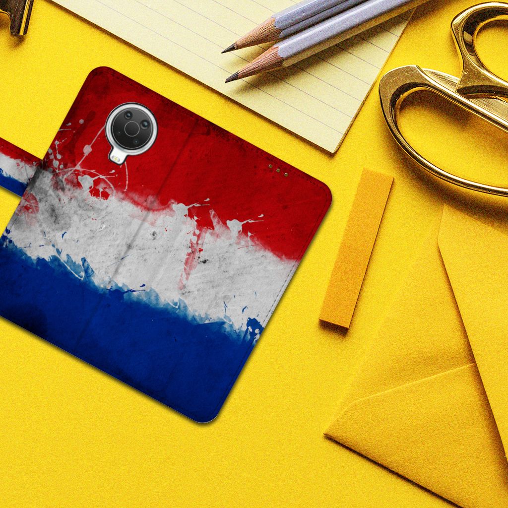 Nokia G10 | G20 Bookstyle Case Nederland met artistiek design van de Nederlandse vlag op een bureau.