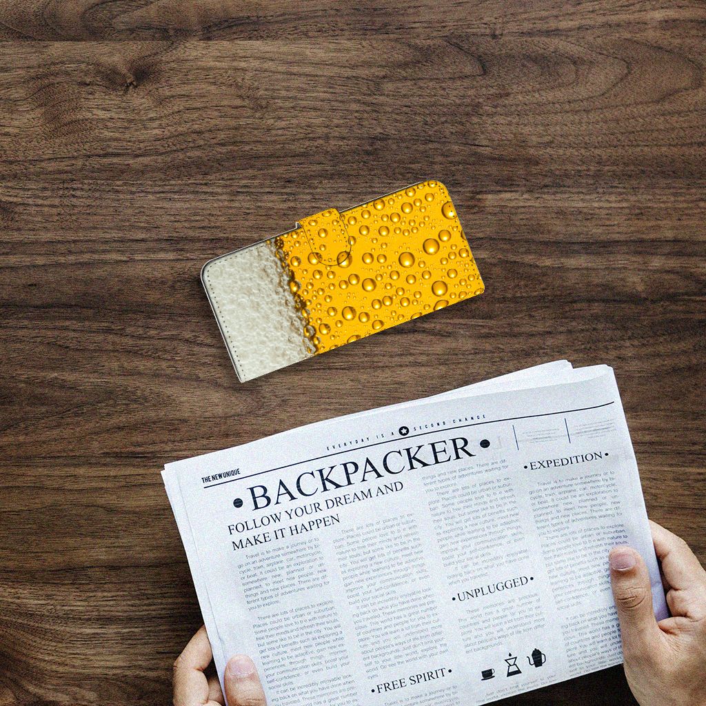 Samsung Galaxy A14 4G Book Cover Bier op een houten tafel met een krant eronder.