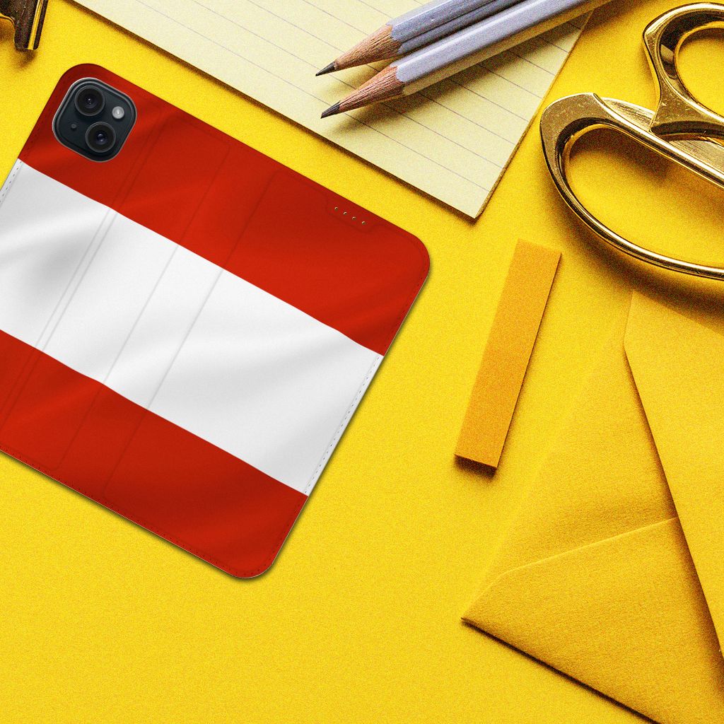 iPhone 15 Plus Standcase Oostenrijk met rood-witte vlag op een gele achtergrond met schrijfmaterialen.