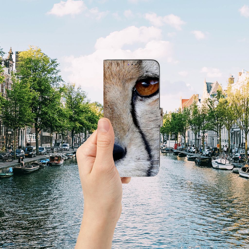 Samsung Galaxy A22 5G Telefoonhoesje met Pasjes Cheetah in hand met een stadsscape op de achtergrond