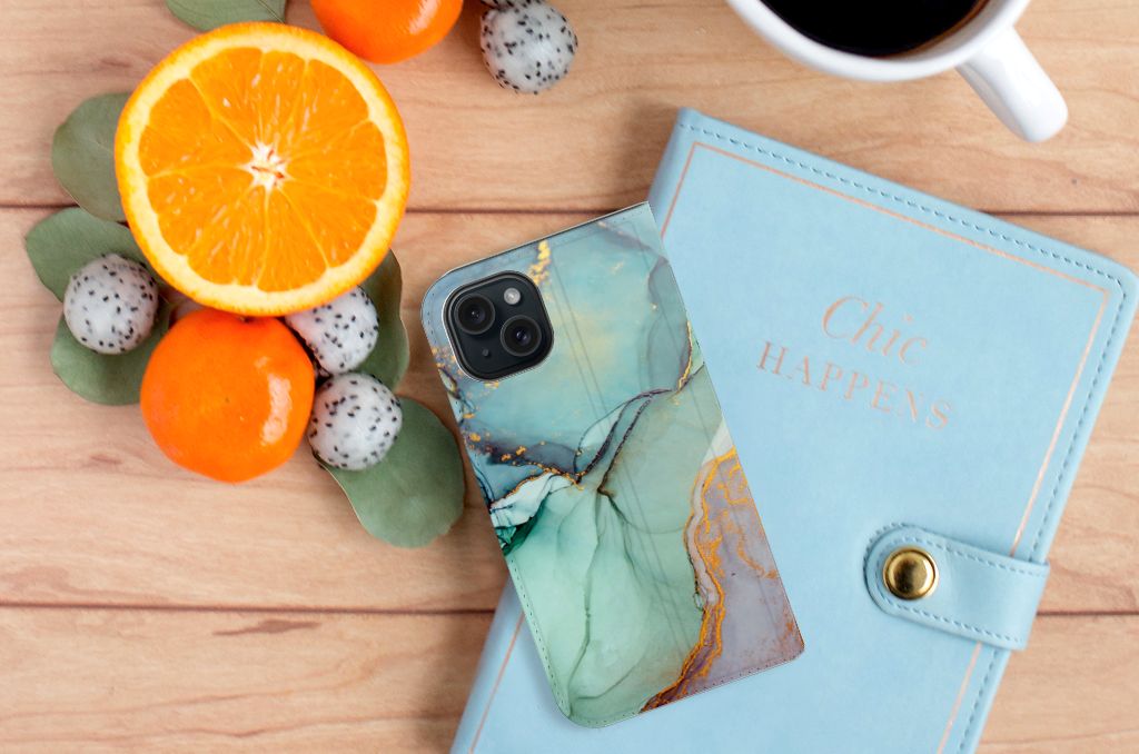 Bookcase voor iPhone 15 Watercolor Mix met kleurrijk design, naast een notitieboek en fruit đ.