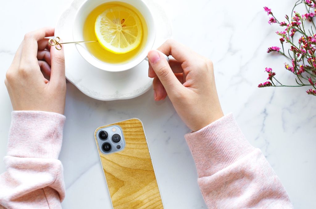 Apple iPhone 13 Pro Bumper Hoesje Licht Hout telefoon en handen met citroen thee