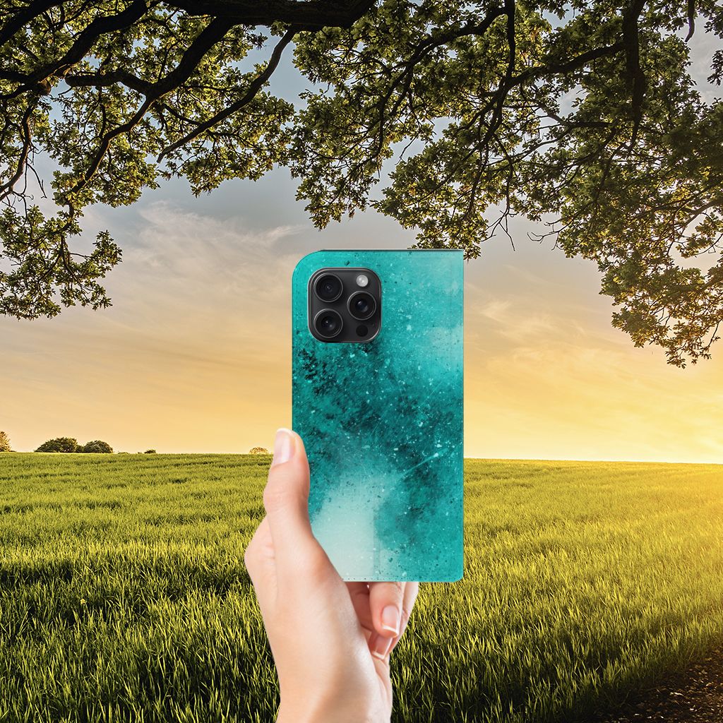 Bookcase iPhone 15 Pro Max Painting Blue: een opvallende groene hoes met een abstract ontwerp in een zonsondergang setting.