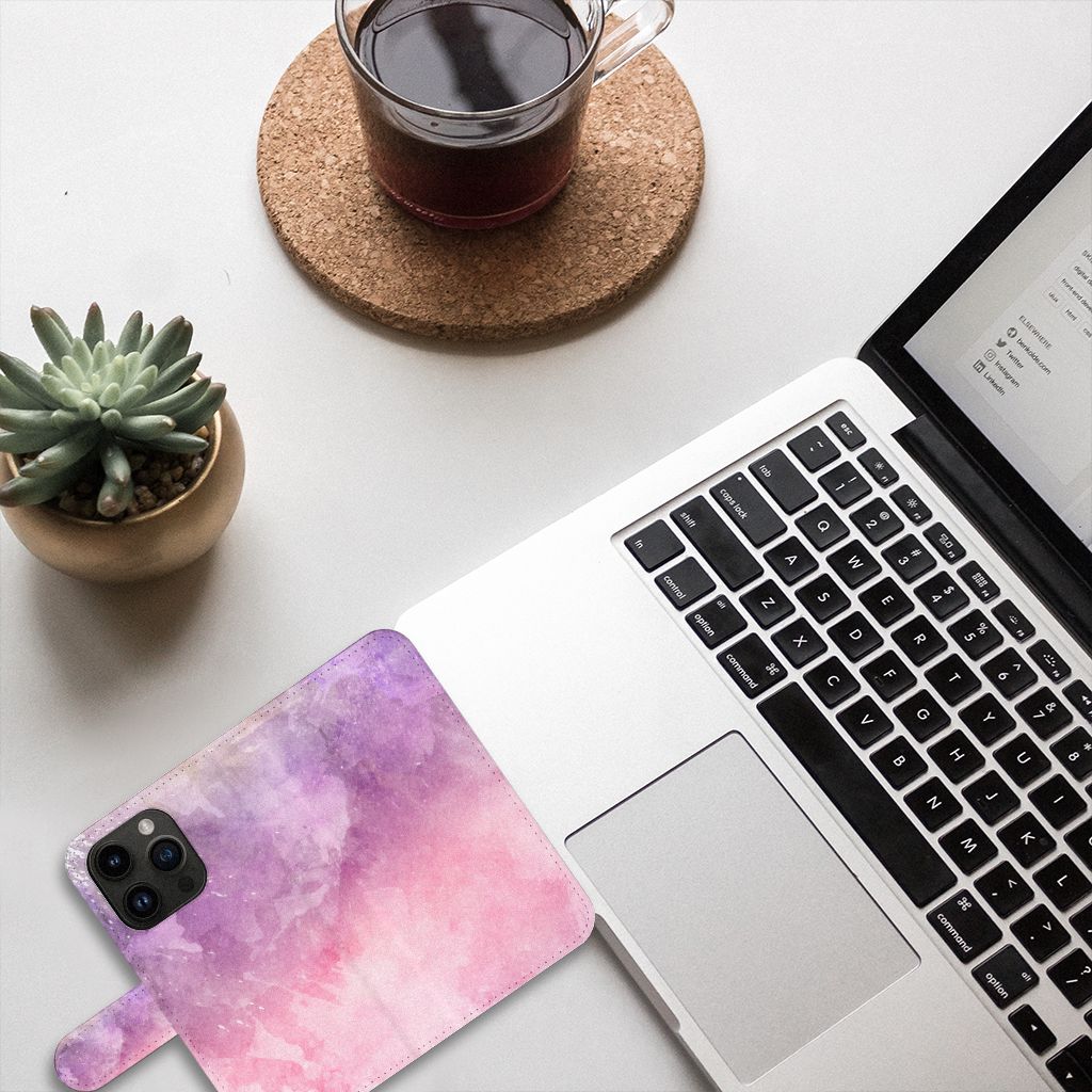 Hoesje iPhone 15 Pro Pink Purple Paint op een bureau met laptop en planten, trendy en beschermend.