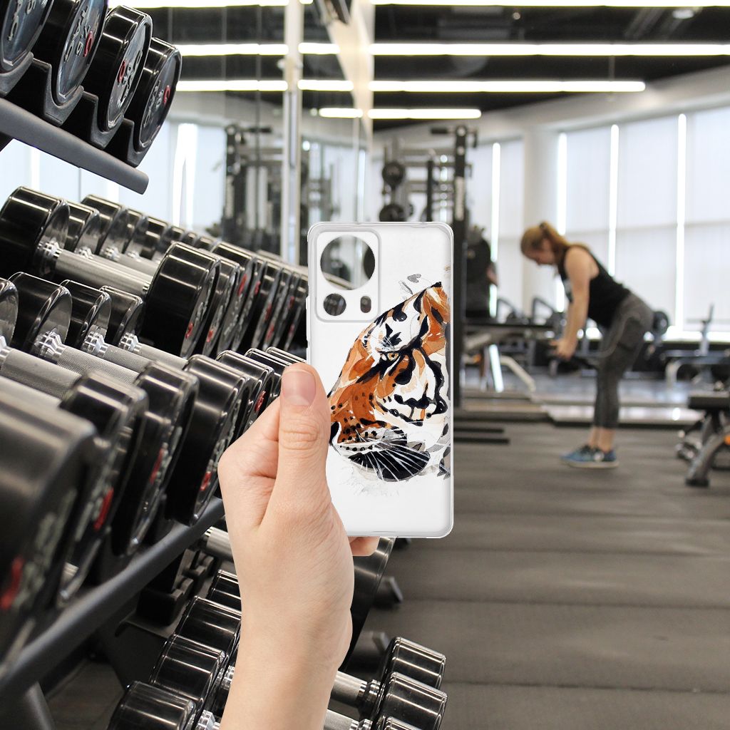 Hoesje maken Xiaomi 13 Lite Watercolor Tiger op een fitnessvloer met halters en een vrouw in de achtergrond.