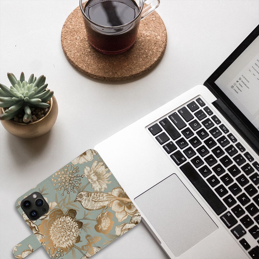Hoesje voor iPhone 15 Pro Vintage Bird Flowers met bloemenprint, laptop en koffie op de achtergrond.