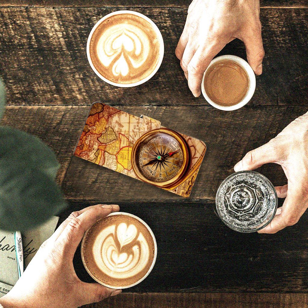 Motorola Edge 40 Flip Cover Kompas op een houten tafel met koffie en een kompas, ideaal als cadeau voor bescherming en uitstraling.
