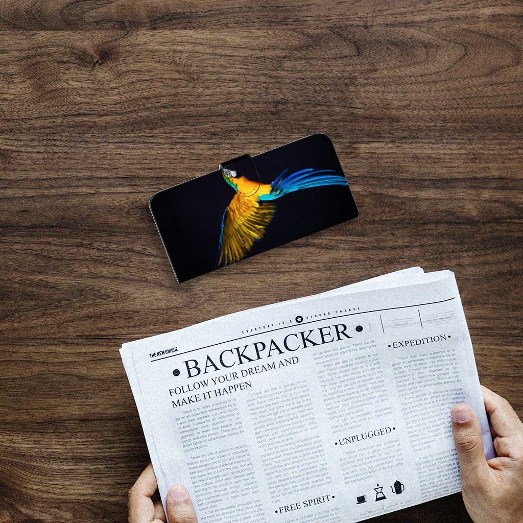 Samsung Galaxy A14 4G Telefoonhoesje met Pasjes Papegaai op een houten tafel met een krant ernaast.