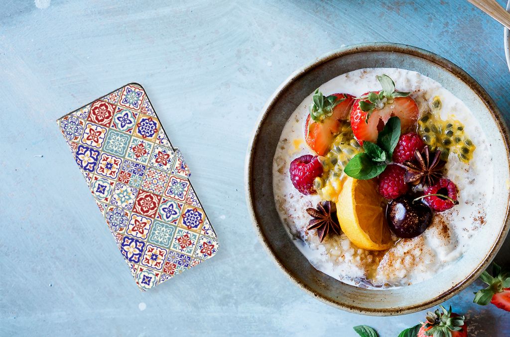 Samsung Galaxy M54 Bookcase Tiles Color naast een kom met fruitsalade en noten, perfect cadeau voor gebruiksgemak en bescherming.