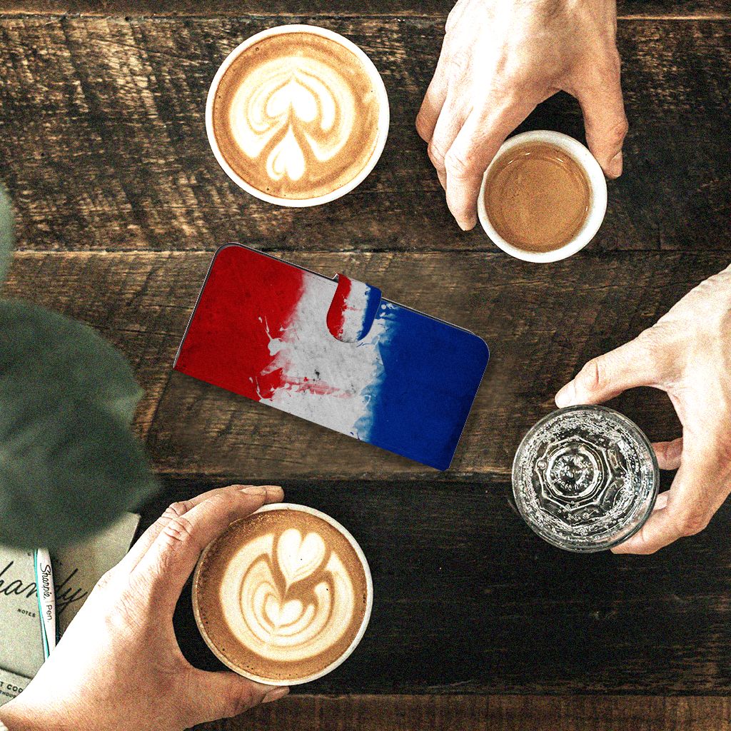 Motorola Moto G84 Bookstyle Case Nederland met artistieke Nederlandse vlag op tafel met koffie