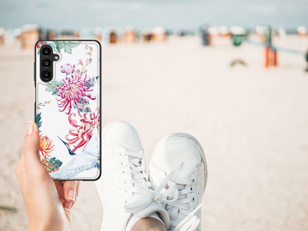 Samsung Galaxy A14 5G Dierenprint Telefoonhoesje Bird Flowers in hand met sneakers op het strand.