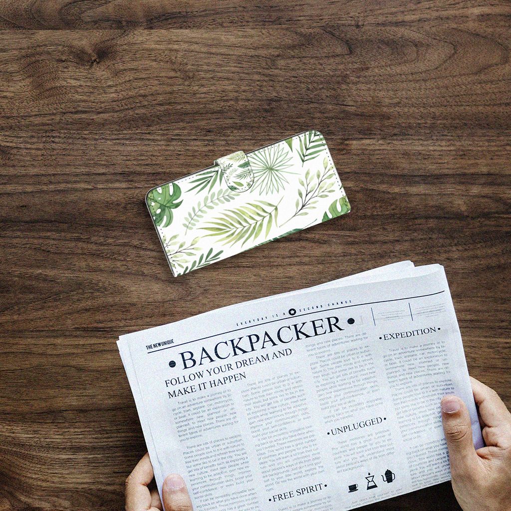 Samsung Galaxy A14 4G Hoesje Leaves met groen bladerenpatroon op een houten tafel naast een krant.