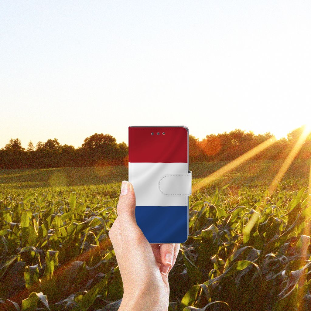 Sony Xperia X Compact Bookstyle Case Nederlandse Vlag in hand, met zonsondergang op achtergrond en maïsveld.