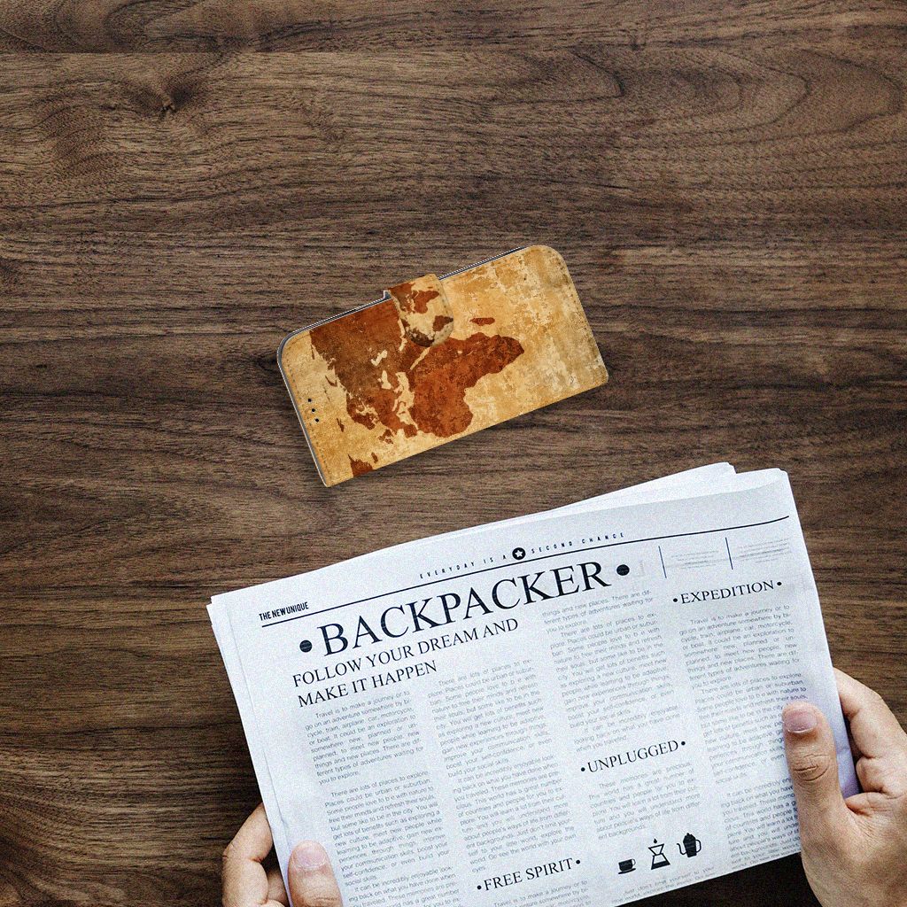Apple iPhone 14 Flip Cover Wereldkaart op een houten tafel met een krant eronder.