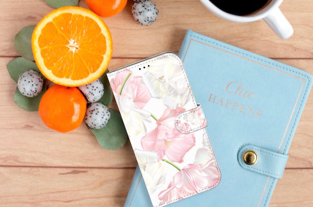 iPhone 14 Plus Hoesje Lovely Flowers met elegante bloemenprint, naast fruit en notitieboekje.