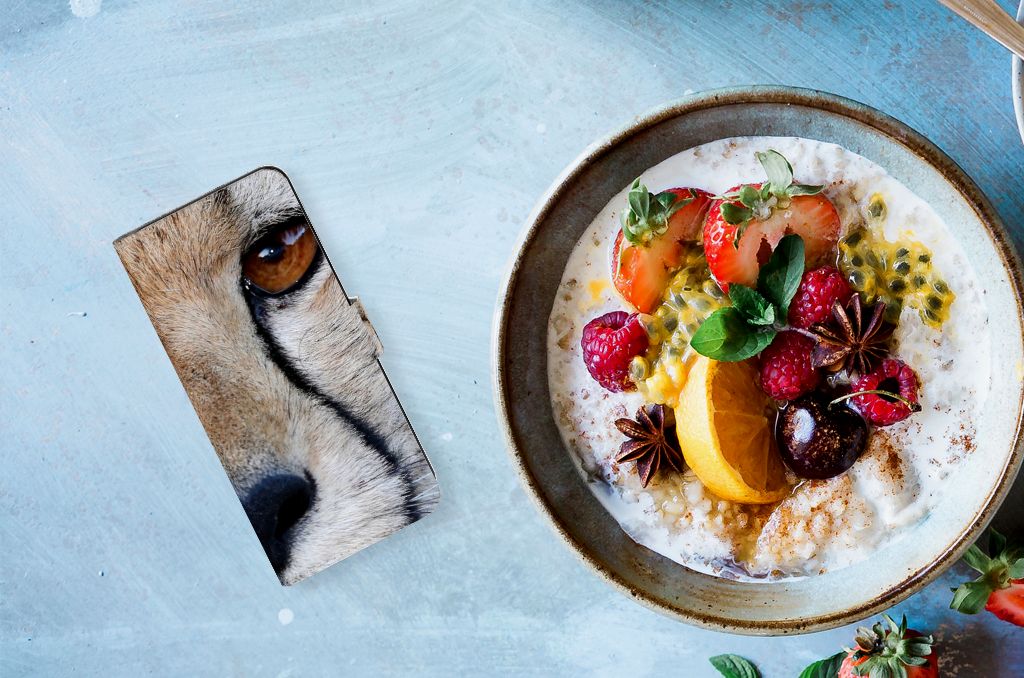 Samsung Galaxy M54 Telefoonhoesje met Pasjes Cheetah naast een kom met fruit en yoghurt.