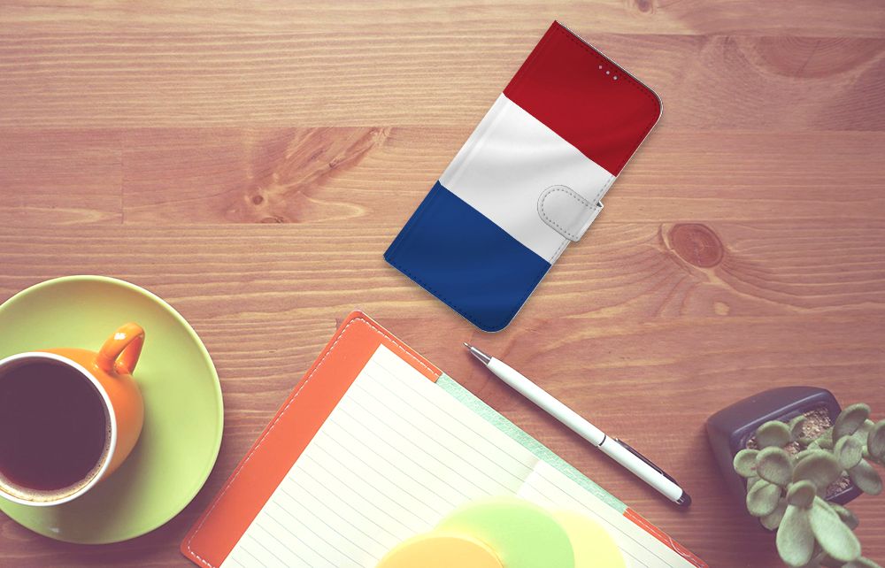Motorola Moto G60s Bookstyle Case Nederlandse Vlag op een houten tafel met een kopje koffie en notitieboek.