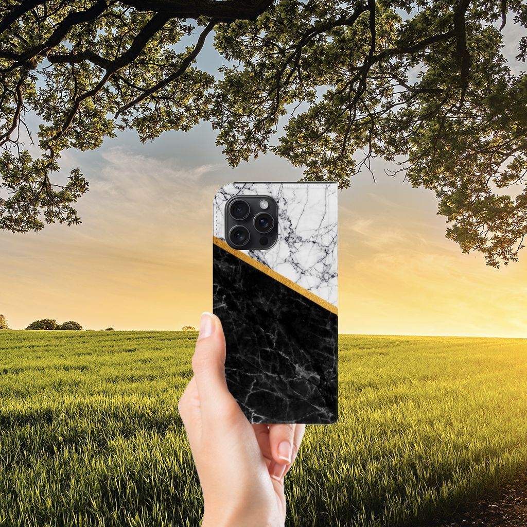 iPhone 15 Pro Max Standcase Marmer Wit Zwart - Origineel Cadeau Man met zwart-wit marmer ontwerp in hand tegen zonsondergang.