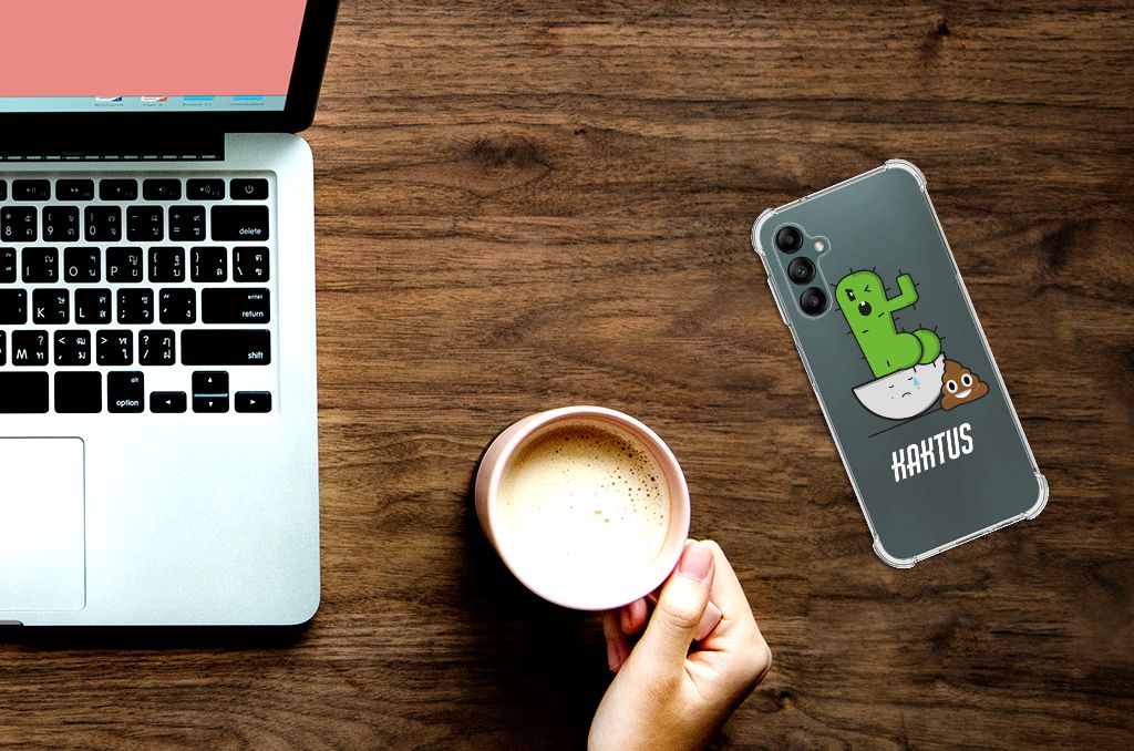 Samsung Galaxy A14 5G/4G Stevig Bumper Hoesje Cactus Poo naast een laptop en een mok koffie.