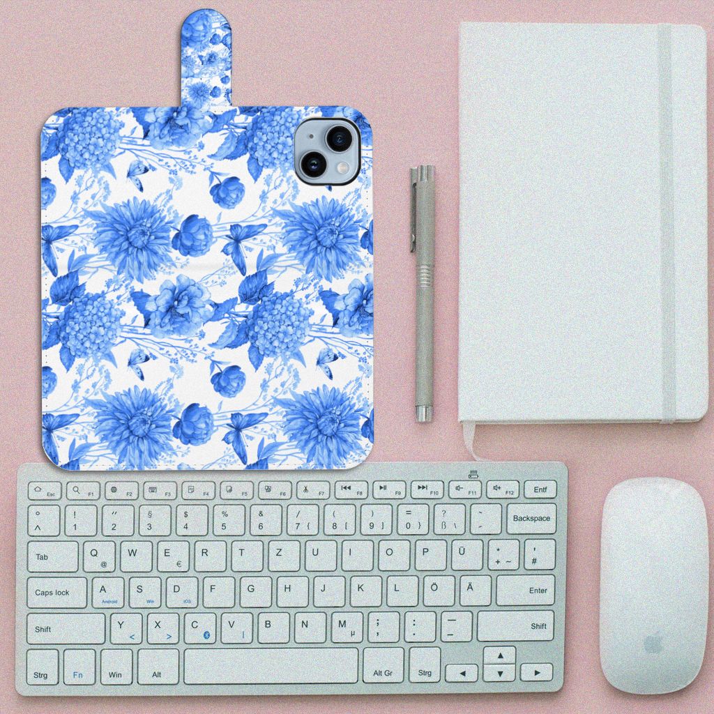 Hoesje voor iPhone 15 Plus Flowers Blue met een prachtig Delftsblauw bloemenontwerp en een toetsenbord ernaast.