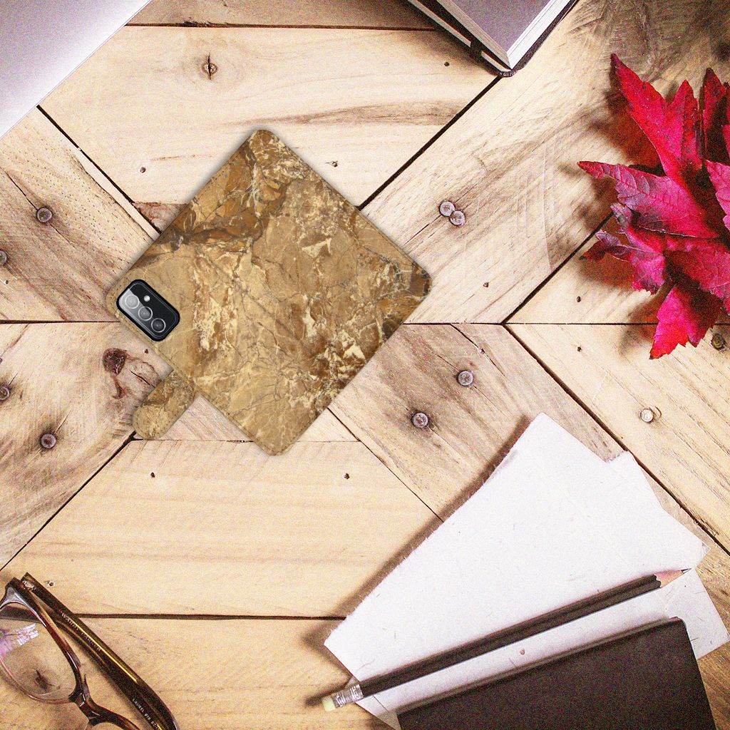 Samsung Galaxy M52 Bookcase Marmer Creme op een houten tafel met kranten en een plantenblad