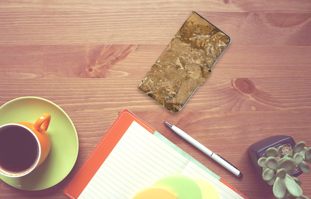 Xiaomi Mi Note 10 Lite Bookcase Marmer Creme op een bureaublad met een kopje koffie en notitieblokken.