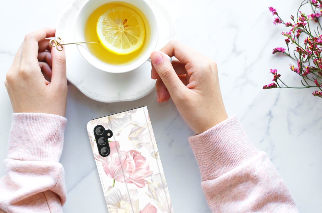 Samsung Galaxy A14 5G Smart Cover Lovely Flowers resting on a table near a cup of lemon tea.