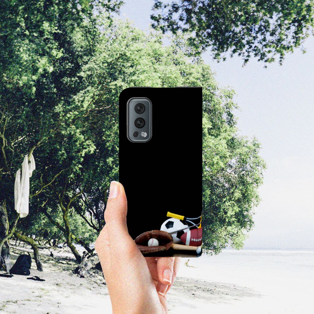 OnePlus Nord 2 5G Hippe Standcase Sports with sports ball designs in a hand on a beach