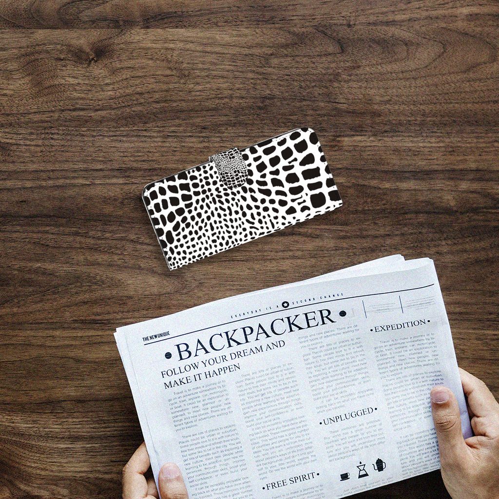 Samsung Galaxy A14 4G Telefoonhoesje met Pasjes Slangenprint op een houten tafel met een krant.