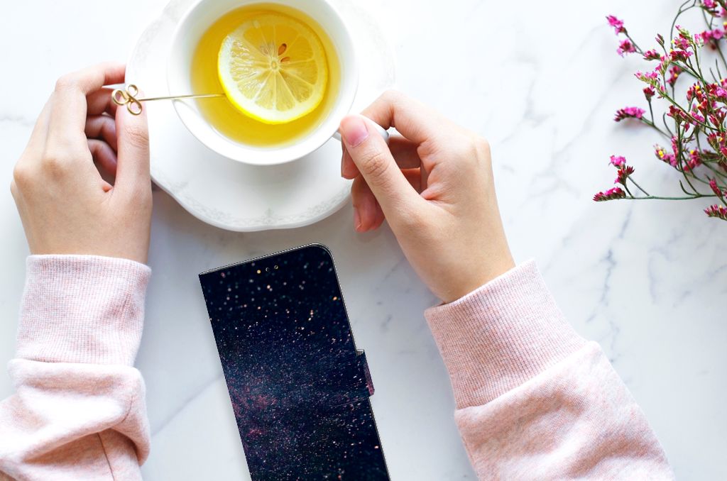 Samsung Galaxy A14 5G Book Case Stars next to a cup of tea with lemon on a marble table.