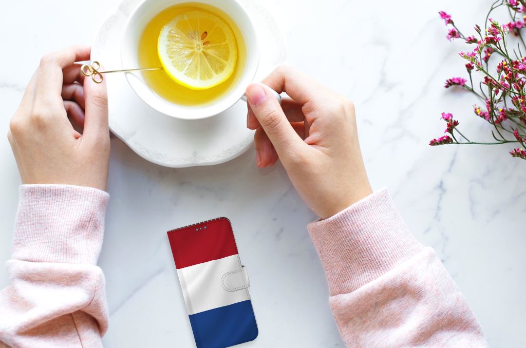 Samsung Galaxy A53 Bookstyle Case Nederlandse Vlag naast een kopje thee op een marmeren tafel.
