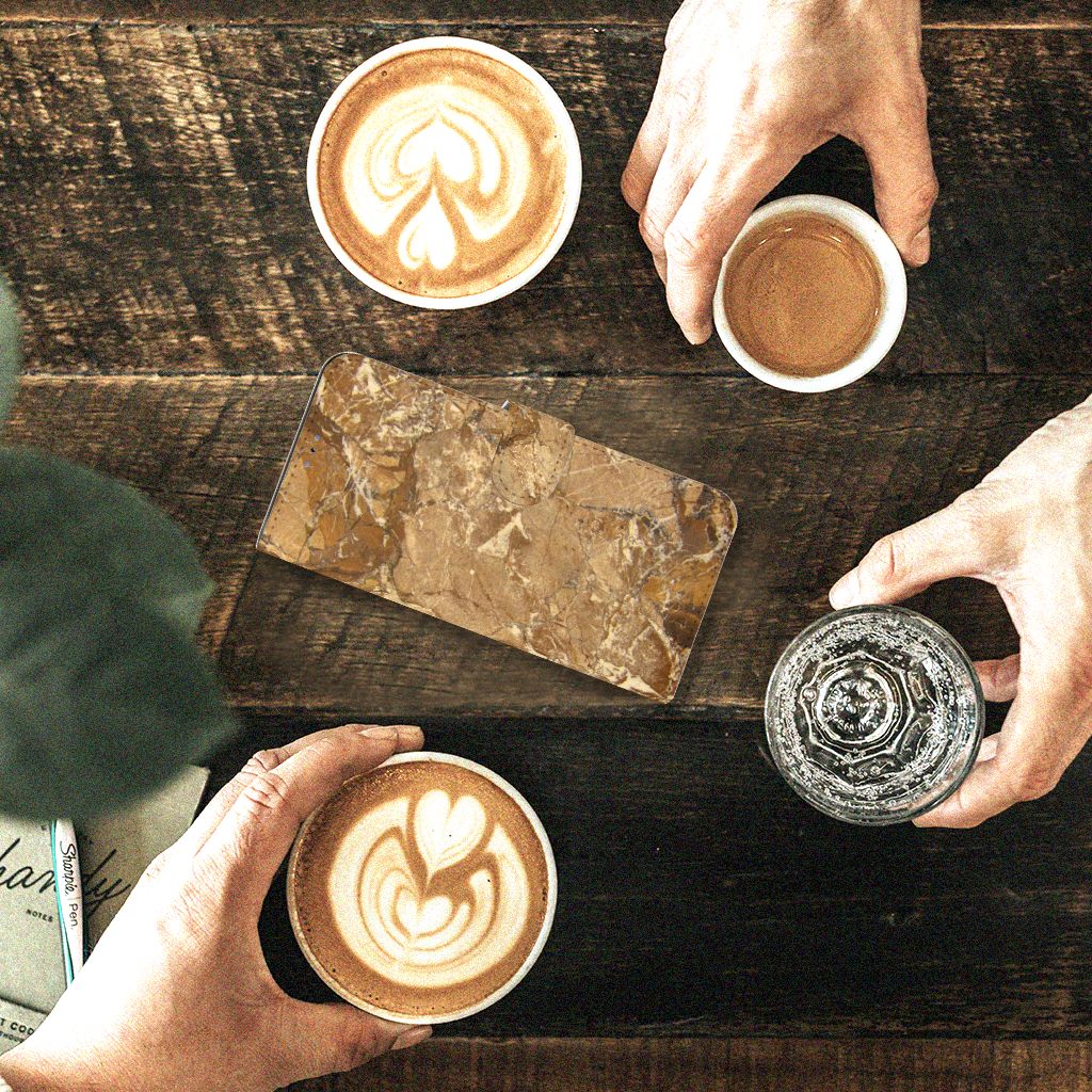 Xiaomi 12 Pro Bookcase Marmer Creme op een tafel met koffie en vrienden.