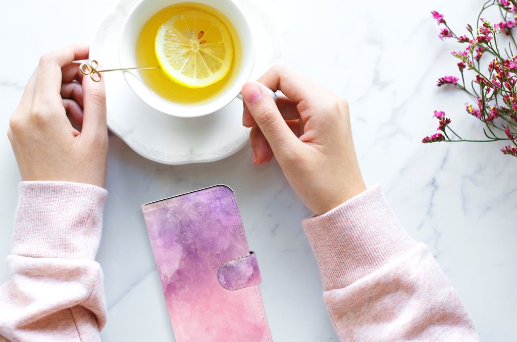 Hoesje iPhone 15 Pink Purple Paint met een hand die een kopje thee vasthoudt en citroen in een schotel.