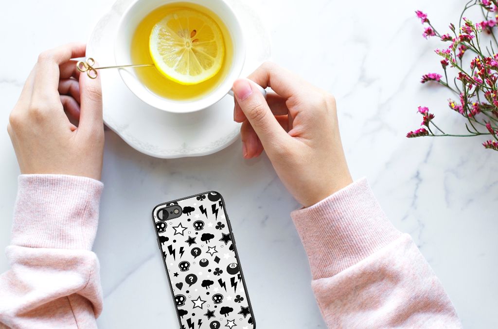 Telefoonhoesje iPhone SE 2022 | SE 2020 | 7/8 Silver Punk met skulls design op tafel naast een kopje thee.
