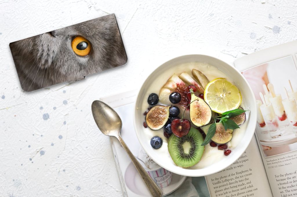 Telefoonhoesje met Pasjes Nokia G42 Britse Korthaar naast een kom met vers fruit en een lepel.