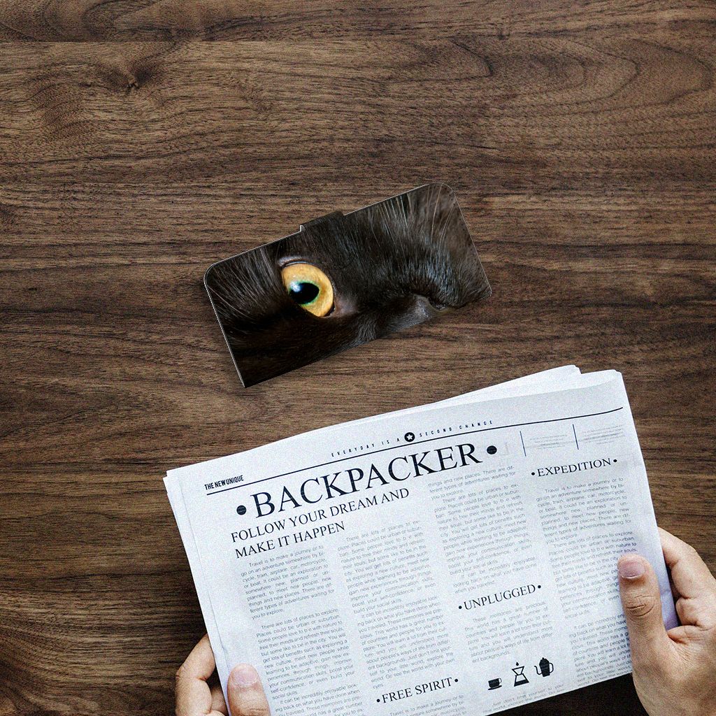 Samsung Galaxy A14 4G Telefoonhoesje met Pasjes Zwarte Kat op een houten tafel met een krant ernaast.