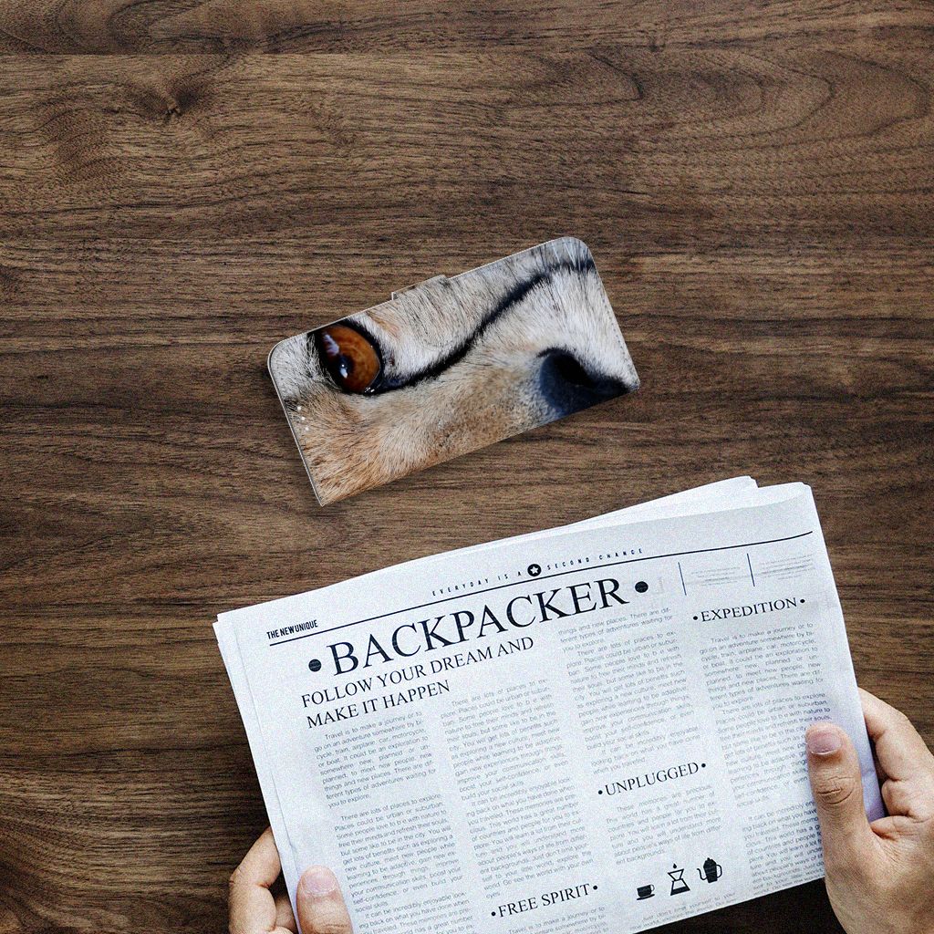 OnePlus 9 Telefoonhoesje met Pasjes Cheetah boven een krant op een houten tafel.