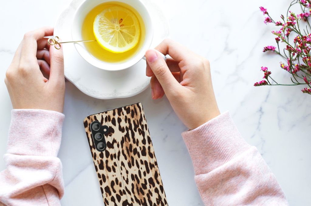 Samsung Galaxy A14 5G Hoesje maken Leopard naast een kopje citroen thee op een marmeren tafel.