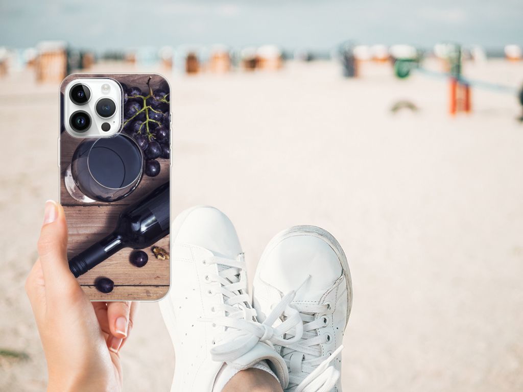 iPhone 14 Pro Max Siliconen Case Wijn met glazen en druiven op een strand, perfecte bescherming voor je telefoon.