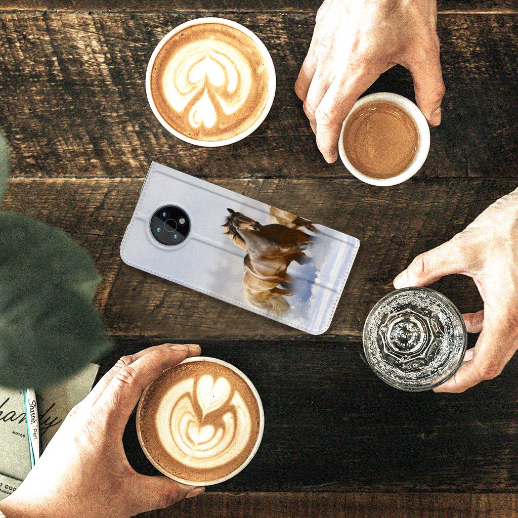 Nokia G50 Hoesje maken Paarden met paardenprint en koffiekopjes op een houten tafel.