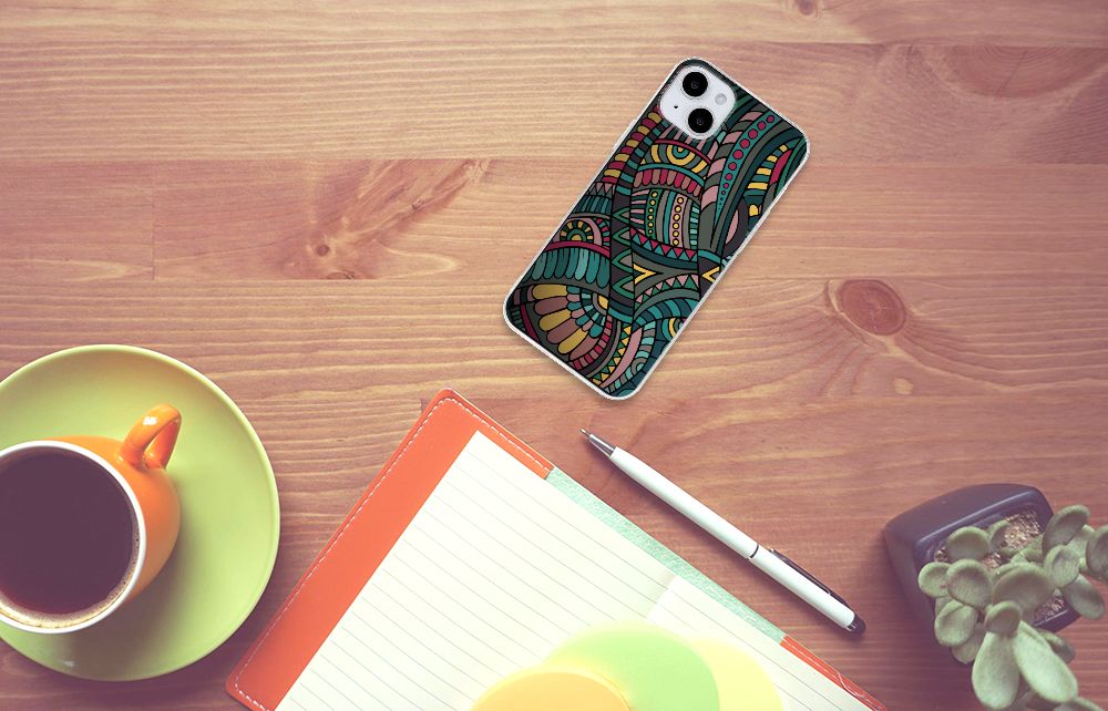 iPhone 15 Plus TPU bumper Aztec met kleurrijk retro ontwerp op een bureau met koffie en notitieboek.