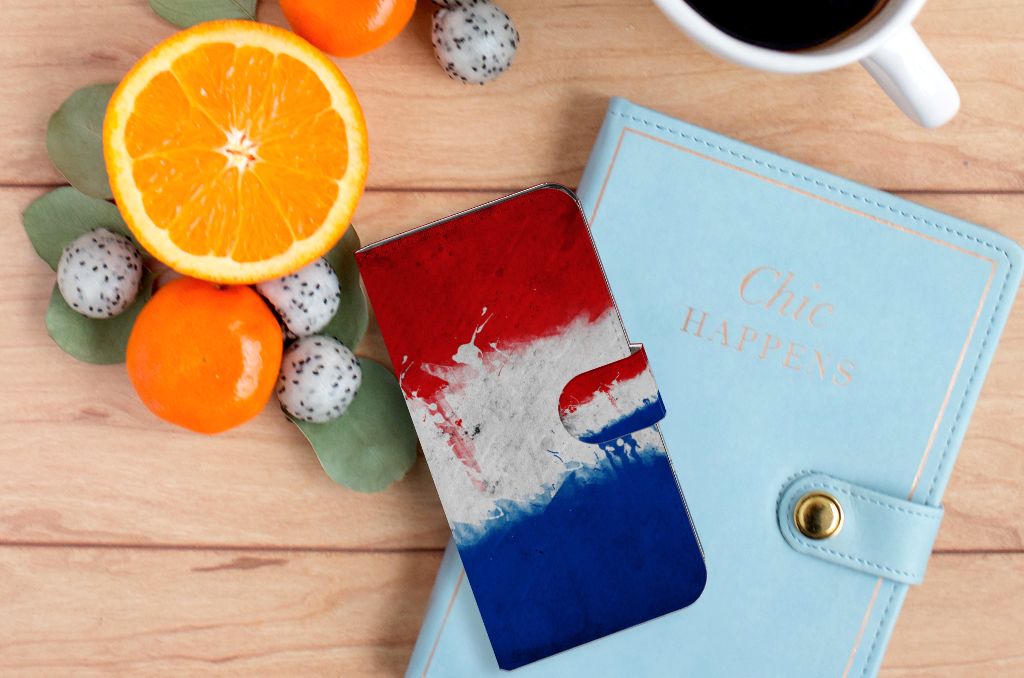 Xiaomi 13 Bookstyle Case Nederland op een houten tafel, omringd door fruit en een notitieboek.