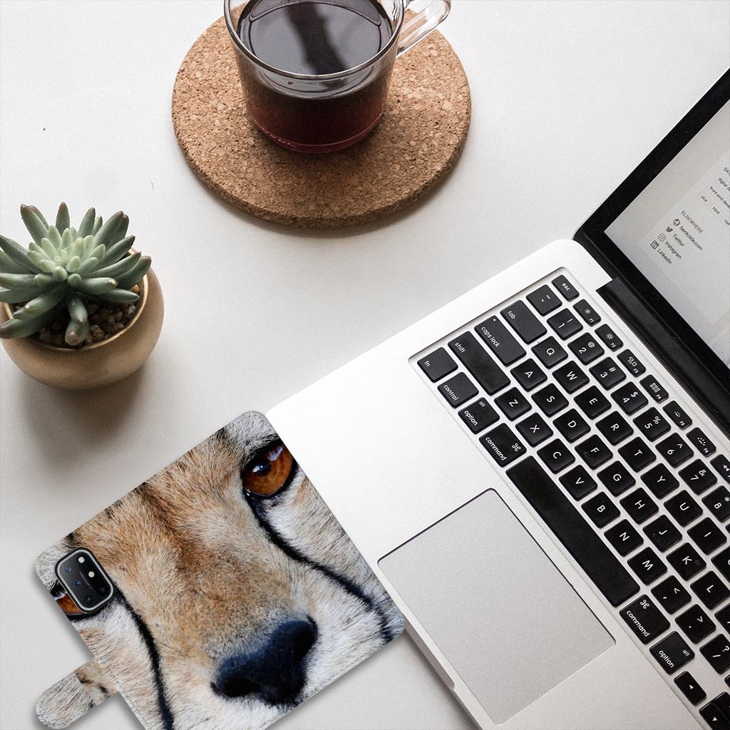 OnePlus 8T Telefoonhoesje met Pasjes Cheetah op bureau met laptop en plant.