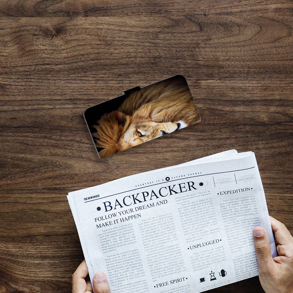 Samsung Galaxy A14 4G Telefoonhoesje met Pasjes Leeuw op een houten tafel met een krant.