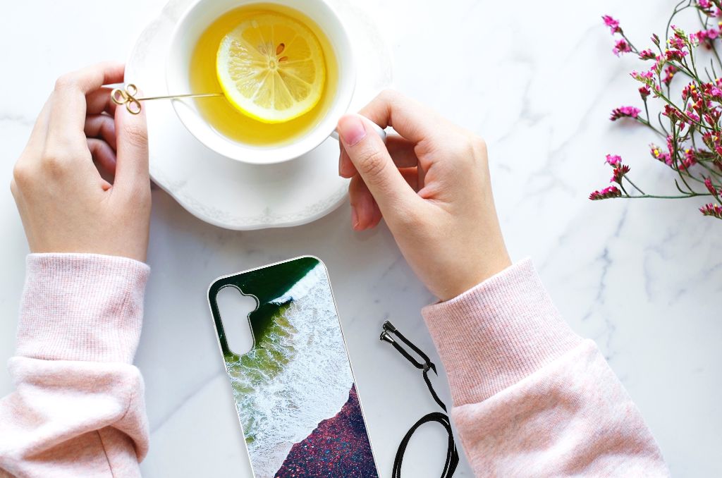 Samsung Galaxy A14 5G Shockproof Case Sea in Space next to a cup of lemon tea on a marble surface.