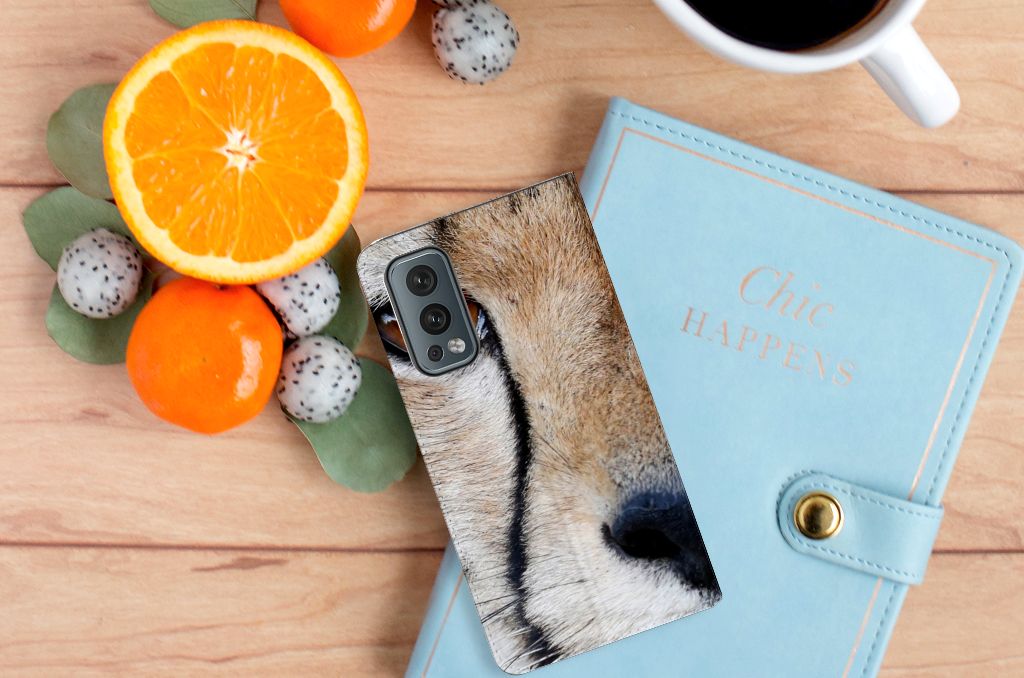 OnePlus Nord 2 5G Hoesje maken Cheetah met close-up van jachtluipaard op een houten tafel met fruit en een notitieboekje.